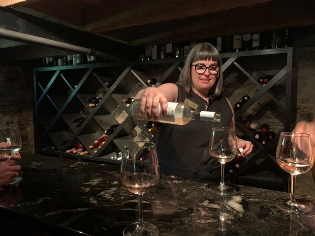 In the original tasting room in the basement of the house, Jayme pours a sample