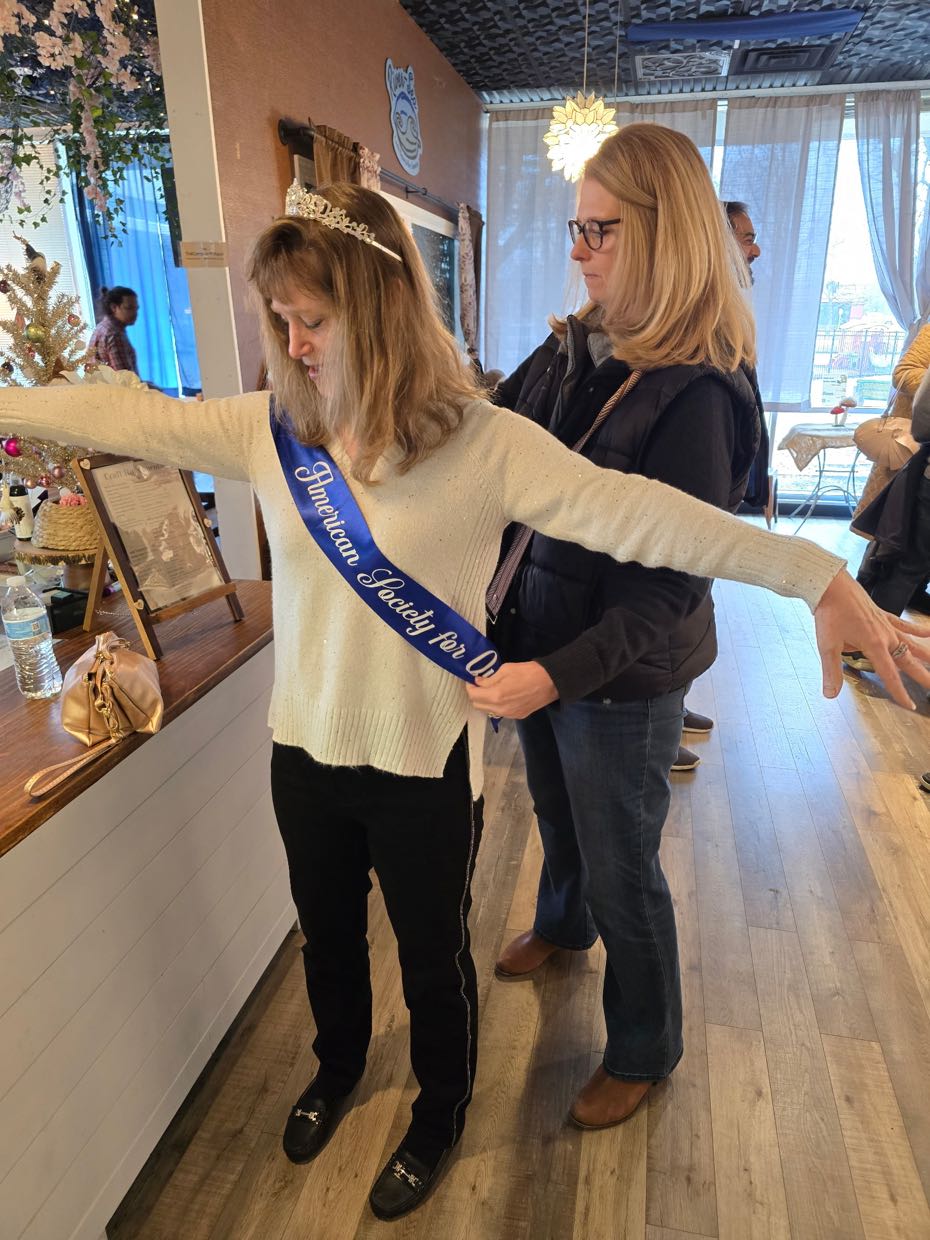 Carolyn Miller putting on her Ranger Outing sash 