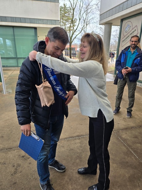 CAroline passing the Ranger Outing sash to the new RO coordinator 